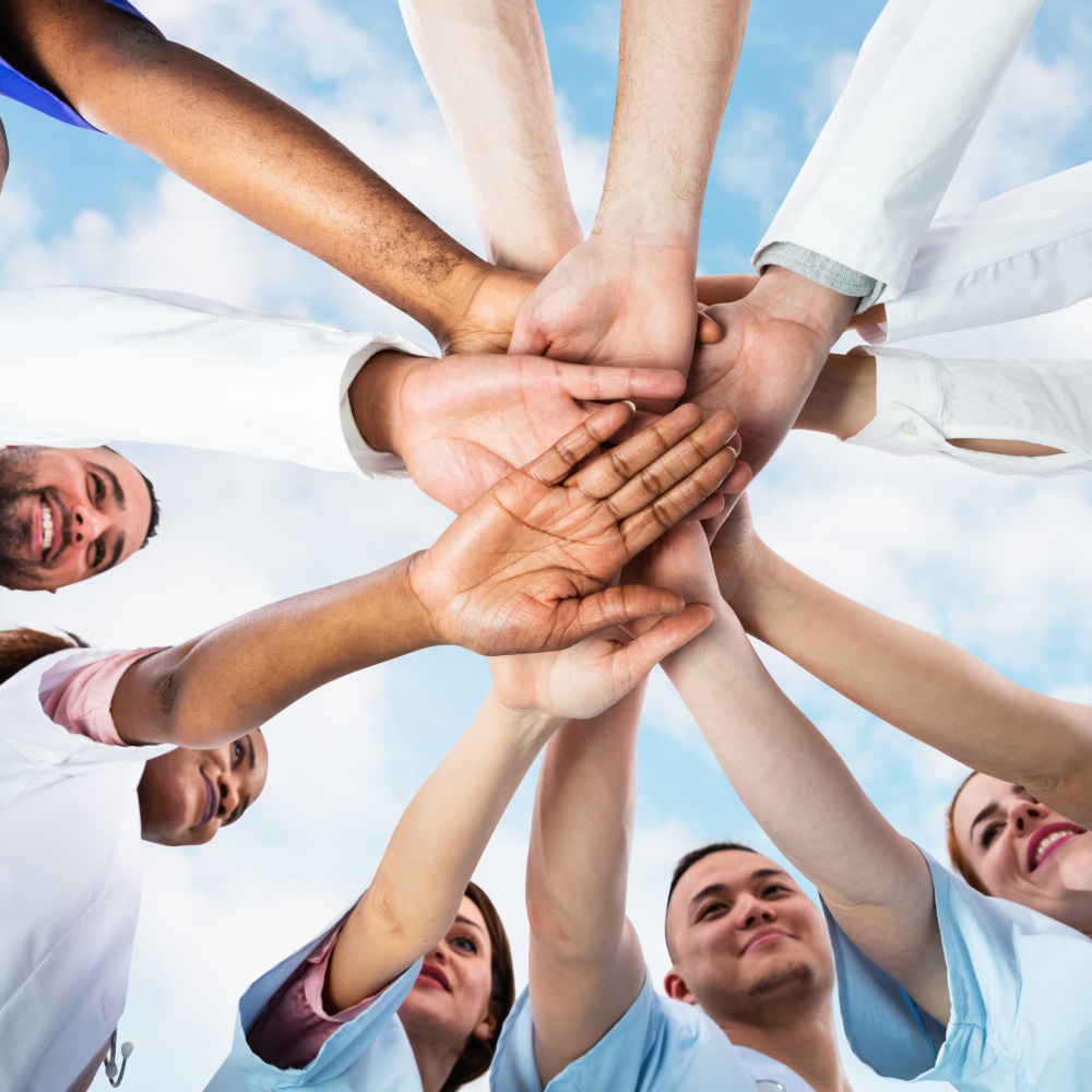 Diverse group of medical professionals putting hands into a circle.